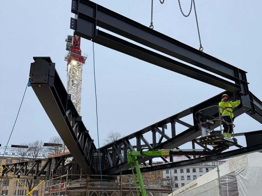 Kran løfter et stålfagverk på plass, Atlas-paviljongen