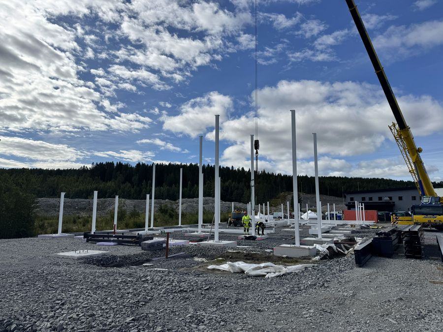 Stålsøyler reises med mobilkran på byggeplassen